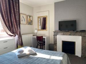 une chambre d'hôtel avec un lit et une cheminée dans l'établissement Hotel Saint Yves, à Nantes