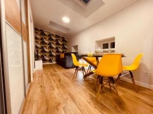 a dining room with yellow chairs and a table at Apartamenty KTW Kościuszki 41 - SKY & DESIGN in Katowice