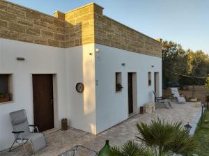 ein weißes Haus mit Ziegelwand in der Unterkunft B & B Pietra Vecchia in Galatone