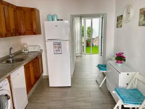 una cucina con frigorifero bianco e lavandino di Casa La Parra, 64 a Nerja