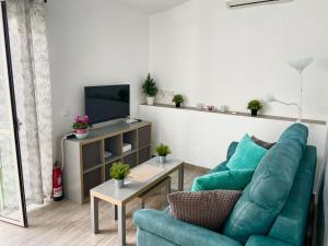 sala de estar con sofá azul y TV en Casa La Parra, 64 en Nerja