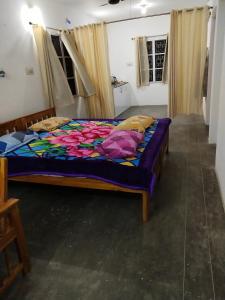 Un dormitorio con una cama con un edredón colorido. en Mayurapriya Inn, en Chennai