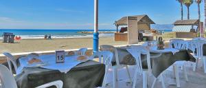 grupa stołów i krzeseł na plaży w obiekcie Apartamento El Palo Beach w Maladze