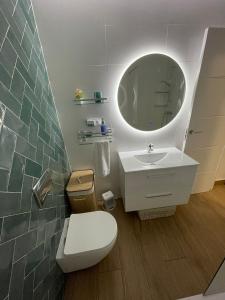 łazienka z toaletą, umywalką i lustrem w obiekcie Apartamento El Palo Beach w Maladze