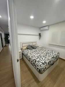 sypialnia z łóżkiem z czarno-białą kołdrą w obiekcie Apartamento El Palo Beach w Maladze