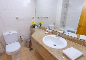 a bathroom with a sink and a toilet and a mirror at Budget Studio Apt near Metro Stn - IRN in Dubai