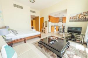 een woonkamer met een bank en een tv bij Budget Studio Apt near Metro Stn - IRN in Dubai
