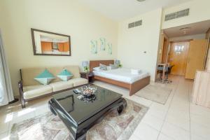 een woonkamer met een bed en een bank bij Budget Studio Apt near Metro Stn - IRN in Dubai