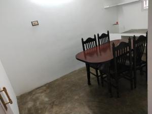 a dining room table and chairs in a room at Mayurapriya Inn in Chennai