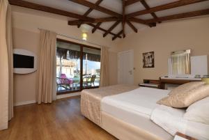 een slaapkamer met een groot bed en een balkon bij Sahra Su Holiday Village & SPA in Ovacik