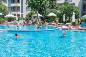 een groep mensen die zwemmen in een zwembad bij Private apartments Aparthotel Excelsior in Sunny Beach