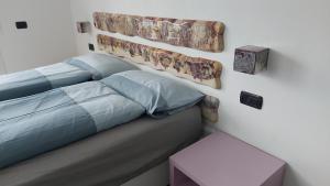 a bed with a headboard and a table in a room at Appartamenti Casa San Nicolò in Malcesine