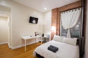 a bedroom with a bed and a table and a window at Studio Plus - One-Bedroom APT in New York