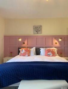 a bedroom with a large bed with a purple headboard at Burrowlodge in Kilfenora