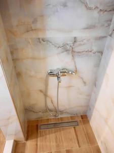 a shower in a bathroom with a marble wall at House with View in Agia Paraskevi +14 photos