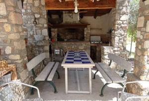 a table and benches on a patio with a fireplace at House with View in Agia Paraskevi