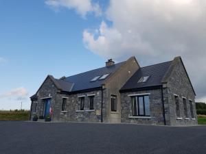 a stone house with solar panels on top of it at Burrowlodge in Kilfenora