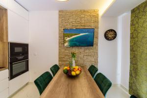 a dining room table with a bowl of fruit on it at Apartmani Bokin in Bol
