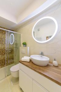 a bathroom with a sink and a toilet and a mirror at Apartmani Bokin in Bol +25 photos