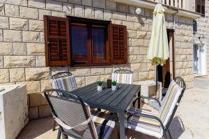 a black table with chairs and an umbrella on a patio at Apartmani Bokin in Bol