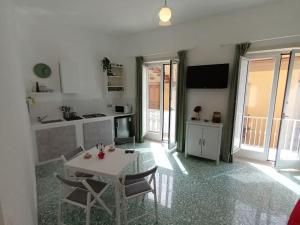 een keuken met een tafel en stoelen in een kamer bij Green Apartment in Sorrento coast in Massa Lubrense