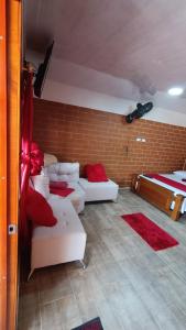 a living room with two white couches and a bed at El Buen Sazon Valluno 