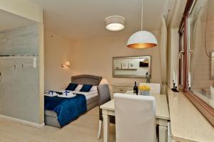 a bedroom with a bed and a dining room with a table at BlueApart Dom Zdrojowy Jastarnia in Jastarnia