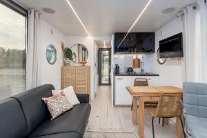 a living room with a couch and a table at Lemuria Houseboat - pływający domek na wodzie in Wrocław