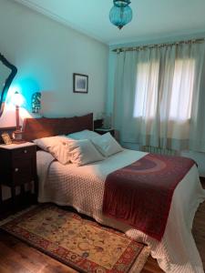 Schlafzimmer mit einem Bett, einem Tisch und einem Fenster in der Unterkunft La Peñona, Carancos48, Nava in Nava