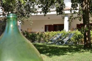 deux chaises assises dans l'herbe devant une maison dans l'établissement Missipezza Residence a Frassanito, à Alimini