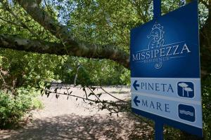 a sign in front of a beach with a tree at Missipezza Residence a Frassanito in Alimini