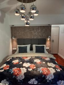 um quarto com uma cama grande e uma colcha floral em Apartments Benic em Zadar