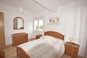 a bedroom with a bed and two dressers and a mirror at Apartamento en Carnota in Carnota