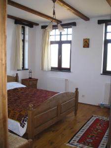 a bedroom with a bed and two windows at Casa Konigstein in Fundata