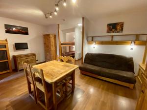 ein Wohnzimmer mit einem Sofa, einem Tisch und einem Bett in der Unterkunft Studio Brides les Bains Savoie in Brides-les-Bains