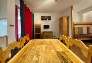 ein Esszimmer mit einem Holztisch und einem Etagenbett in der Unterkunft Studio Brides les Bains Savoie in Brides-les-Bains