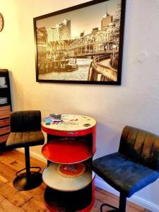 una habitación con 2 sillas, una mesa y una foto en ***Ferienwohnung Hamburger Original***, en Halstenbek