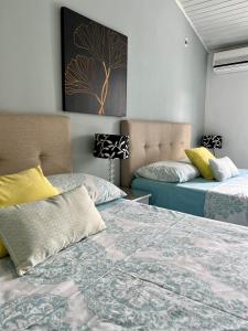 a bedroom with two beds and a tree picture on the wall at Casa Norte Exclusive Home-Amplia, amoblada Valledupar in Valledupar +57 photos