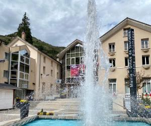 einem Brunnen vor einem Gebäude in der Unterkunft Studio Brides les Bains Savoie in Brides-les-Bains