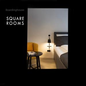 a room with a bed and a table with a bed and a chair at Square Rooms 8 in Düsseldorf