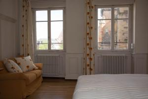 コルマールにあるlesboisjolisのベッドルーム1室(ベッド1台、ソファ、窓付)
