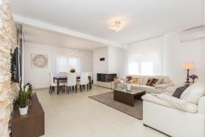 sala de estar con muebles blancos y comedor en Guest house Casa Dia en Labin