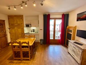 ein Wohnzimmer mit einem Tisch und einer Küche in der Unterkunft Studio Brides les Bains Savoie in Brides-les-Bains
