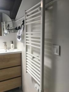 a bathroom with a sink and a towel rack at La casita de Olivia Espinaredo in La Villa +97 photos