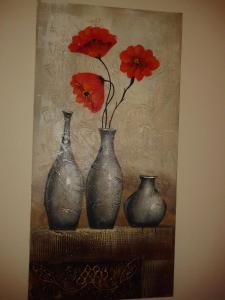 een schilderij van drie vazen met rode bloemen erin bij Turquoise View Guesthouse in Middelburg