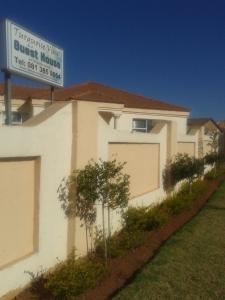a white house with a sign in front of it at Turquoise View Guesthouse in Middelburg