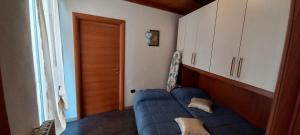 een woonkamer met een blauwe bank voor een deur bij Casa Mango in Stresa