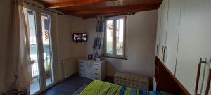a bedroom with a bed and a dresser and windows at Casa Mango in Stresa +9 photos