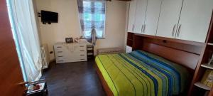 - une chambre avec un lit, une commode et une fenêtre dans l'établissement Casa Mango, à Stresa