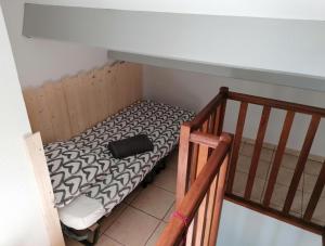 een klein bed in een kamer naast een trap bij Duplex terrasse vue mer accès plage et piscine... in Frontignan